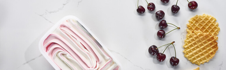 top view of delicious waffles, cherries and ice cream on marble grey background, panoramic shot