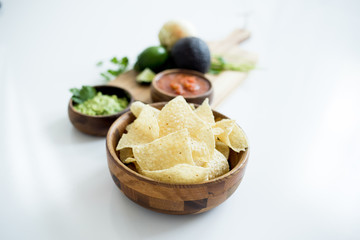 Chips with salsa and guacamole on white background