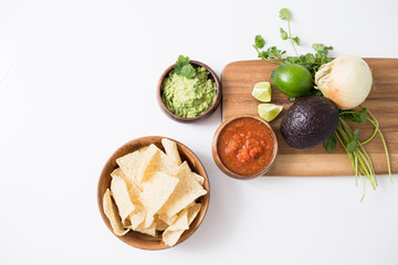 Chips with salsa and guacamole on white background