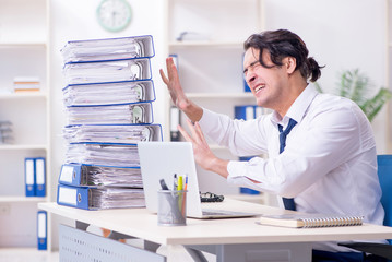 Obraz premium Young male employee unhappy with excessive work