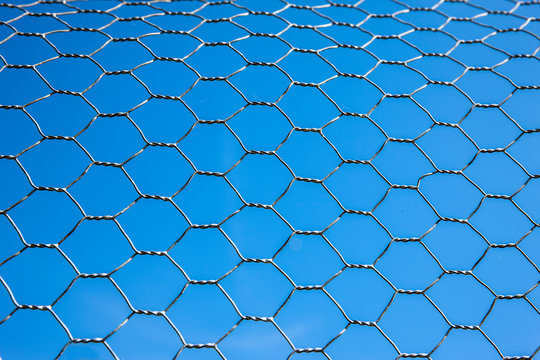 Maschendraht vor blauem Hintergrund