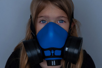 Young girl wearing gasmask, respirator portrait. Effects of worldwide air pollution, industrial...