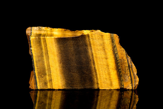 Tigerauge oder Goldquarz Rohstein vor Hintergrund schwarz, Mineralien und Heilsteine