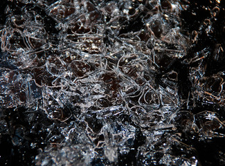 An abstract image of the surface of broken ice against a dark background