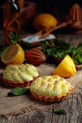 Tartlets with lemon cream and mint on a old wooden table.
