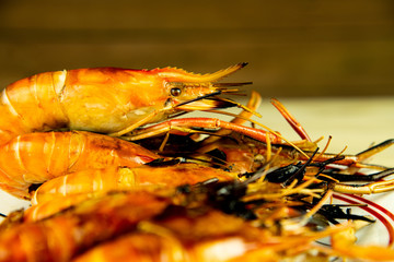Delicious fresh jumbo grilled shrimps ( head on ), most popular Thai seafood on blur background. © Jack Tamrong