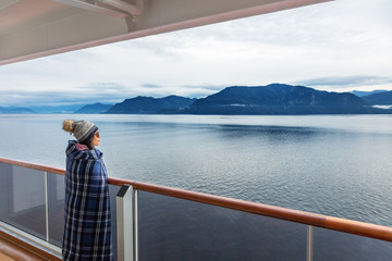 Alaska cruise travel luxury vacation woman watching inside passage scenic cruising day on balcony...