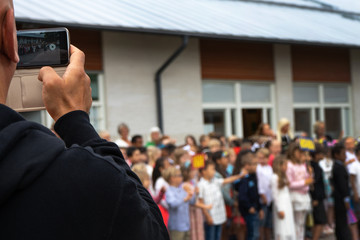 Tumba, Sweden - june.14.2018: A man takes pictures of children on a mobile phone. Circa Salem kommun.