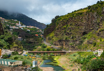 Obraz premium Mountain landscape. Depicted mountains, gorge, winding road and viaduct. The winding road encircles the mountain, on the road going machine.