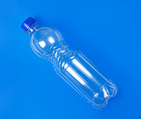 Plastic bottles on blue background. Glare on bottles