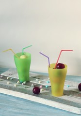  Fruits in cocktail glasses with tubules and vitamin-hearts on a wooden table, the concept of love for healthy food, the season of summer, autumn