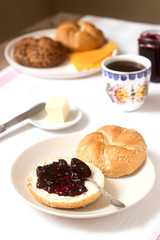 Breakfast with Kaiser rolls, currant jam, butter and cheese and tea.