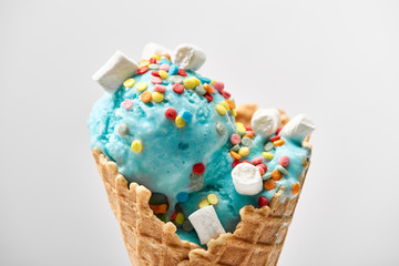 close up view of delicious sweet blue ice cream with marshmallows and sprinkles in crispy waffle...