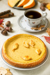 Traditional American pumpkin homemade cake, decorated with cookies on a background of pumpkins and autumn leaves.