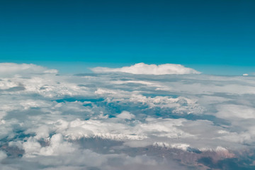 Fototapeta na wymiar Clouds and mountains. Airplane view.