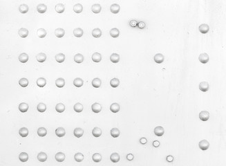 White metal wall with rivets and bolts