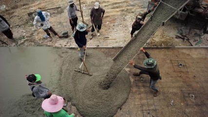 Top view group of worker loading the mixed cement from the truck for building the cement floor at construction site
