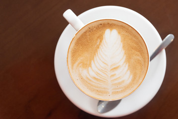 Coffee cup with latte art foam on wood table in coffee shop with copy space.Coffee is one of the most popular beverages.Improve Energy Levels and Burn Fat