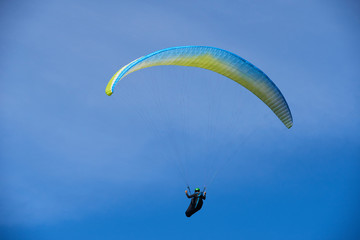 Paraglider flying over the Garda Lake (Lago di Garda or Lago Benaco), Panorama of the gorgeous Garda lake surrounded by mountains. Paragliding is very popular sport in Monte Baldo. Malcesine, Italy