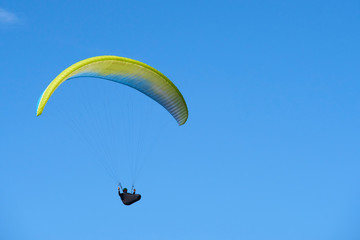 Paraglider flying over the Garda Lake (Lago di Garda or Lago Benaco), Panorama of the gorgeous Garda lake surrounded by mountains. Paragliding is very popular sport in Monte Baldo. Malcesine, Italy