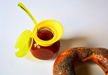 Fresh donated crispy bagel with poppy seeds on a white plate with tasty natural apricot jam and a...