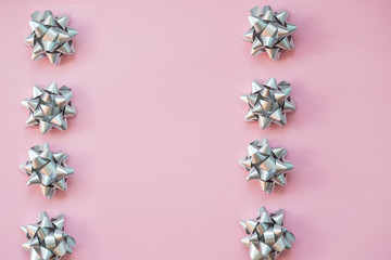 Gift wrapping. Modern Christmas gifts presents.Object for wrapping present boxes.Set of silver bows on pink background. Holiday's ribbon bows for decoration gifts