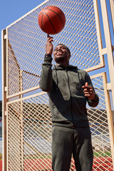 African american guy with a basketball is training on the court