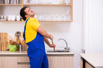 Young male contractor repairing tap at home © Elnur