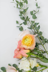 Pink and Orange Flowers with Greenery on White Background, Copy Space, Roses, Peonies, and Green Flowers