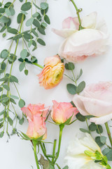 Fototapeta na wymiar Pink and Orange Flowers with Greenery on White Background, Copy Space, Roses, Peonies, and Green Flowers