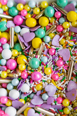 Fototapeta na wymiar Group of Colorful Sprinkles, Bright Candy Sprinkle Background Up Close, Copy Space