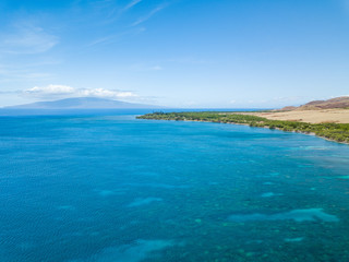Drone side view of the dry mountains and crystal clear waters of the Lahaina Coast on the island of Maui, Hawaii