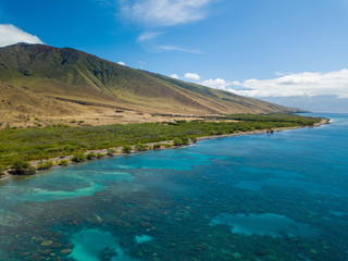 Naklejka na ściany i meble Drone side view of the dry mountains and crystal clear waters of the Lahaina Coast on the island of Maui, Hawaii