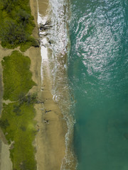 Drone top down view of the crystal clear water, crashing waves, and natural beachs of the Lahaina Coast on the island of Maui, Hawaii