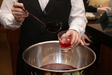 Bartender hand pouring fruit punch  in nightclub, bar or pub.