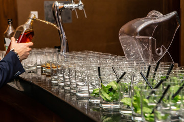 Bartender hand pouring alcoholic drink whiskey in nightclub, bar or pub.