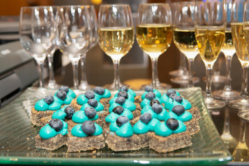 Catering food: dessert, mini canapes, sweetmeat and glass of champagne. Food and drinks for the event. 