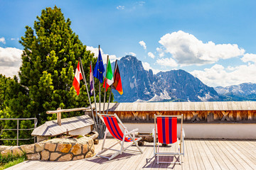 beautiful view to place of rest with sunbeds near funicular Col Raiser, captured with one of the dolomites famous mountains, the Sassolungo or Longkofel, in the background, on sunny summer clear day