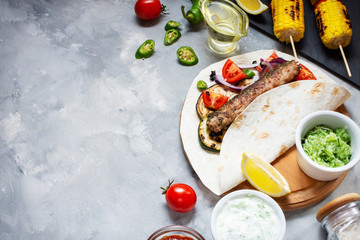 Assorted delicious grilled vegetables and doner kebab on a concrete background. Summer food barbecue.