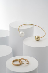 Golden bracelet with pearl on white cylinders and golden rings