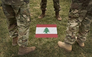 Flag of Lebanon and soldiers legs on the grass (collage).