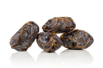 Group of four whole dried brown date medjool isolated on white background