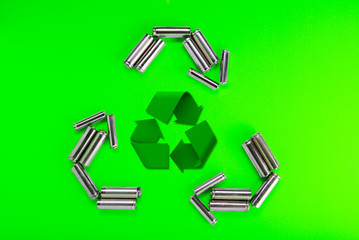 Batteries in the form of recycling on a green background. Battery recycling, environmental concept.