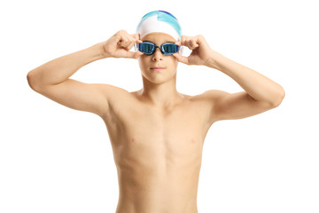 Teenage boy swimmer with a cap putting on goggles
