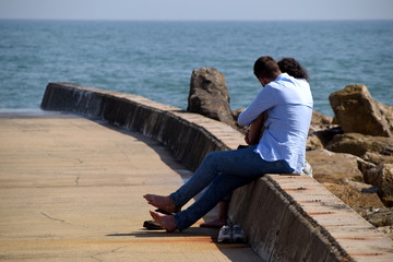 A couple in sweet affectionate effusions in front of the sea