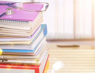 Stethoscope with a stack of reference books isolated