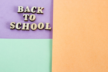 Colorful paper background. The inscription "back to school." The concept of holiday knowledge.