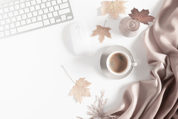 Autumn home cozy composition. Women's home office desk. Dried autumn leaves, cup of coffee, computer on white background. Fall relax background. Flat lay, top view, copy space