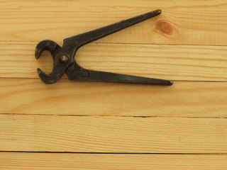 Old rusty pincers on a wooden background. A tool for gripping and pulling things.