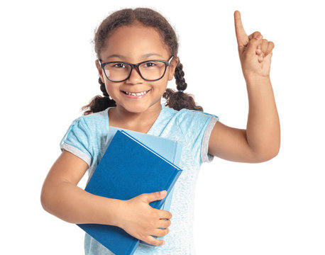 Adorable little African-American schoolgirl with raised index finger on white background